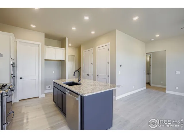a kitchen with kitchen island granite countertop a sink and refrigerator