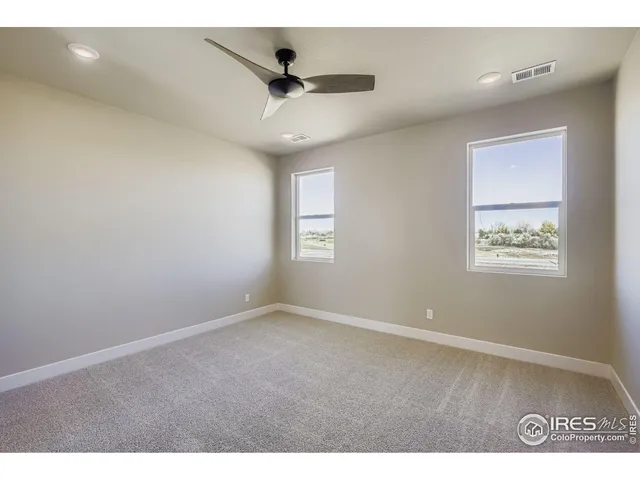 a view of an empty room and chandelier fan