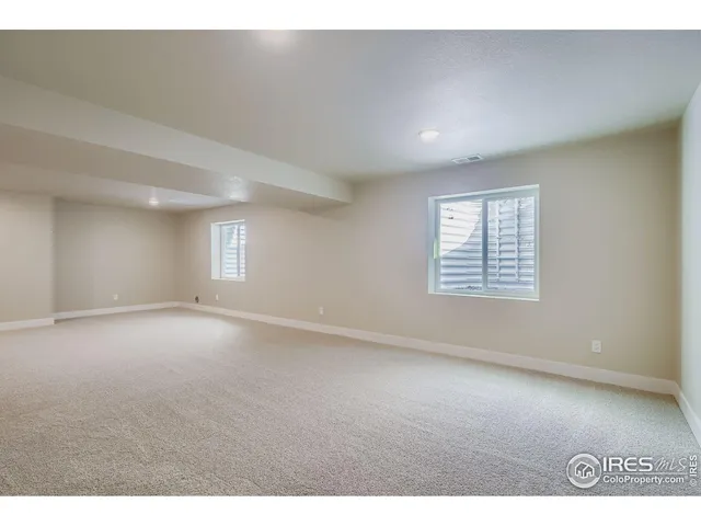 a living room with furniture white walls and kitchen view
