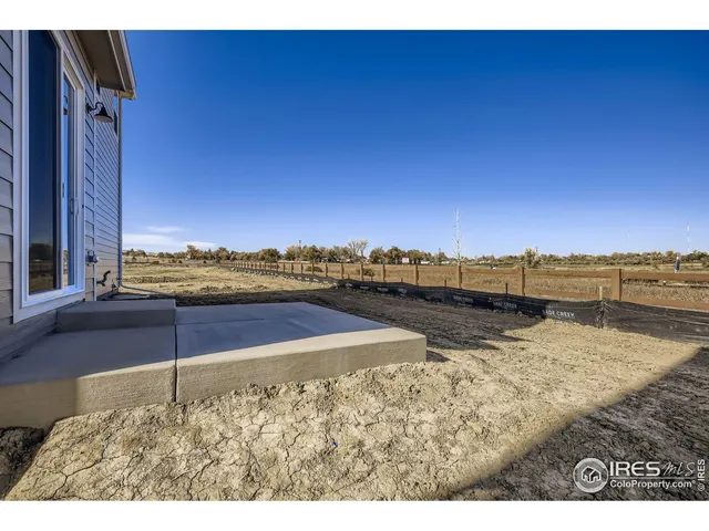 a view of a dry yard with wooden fence