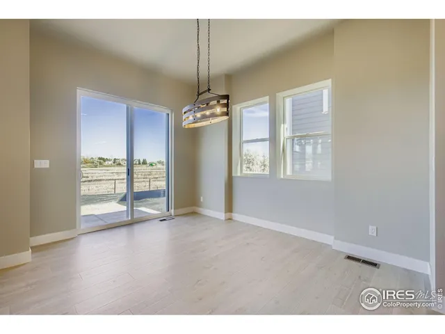 a view of an empty room with window and closet