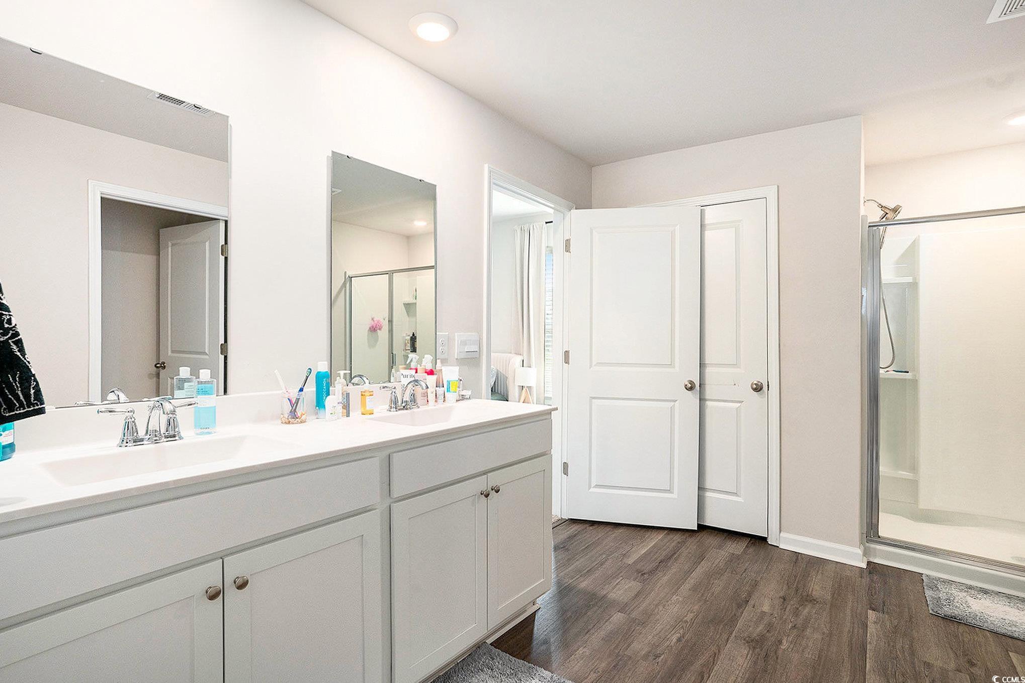 1178 Sennema Circle Myrtle Beach, SC 29588 - Photo 15 of 31 Bathroom with a stall shower, double vanity, and dark wood finished floors