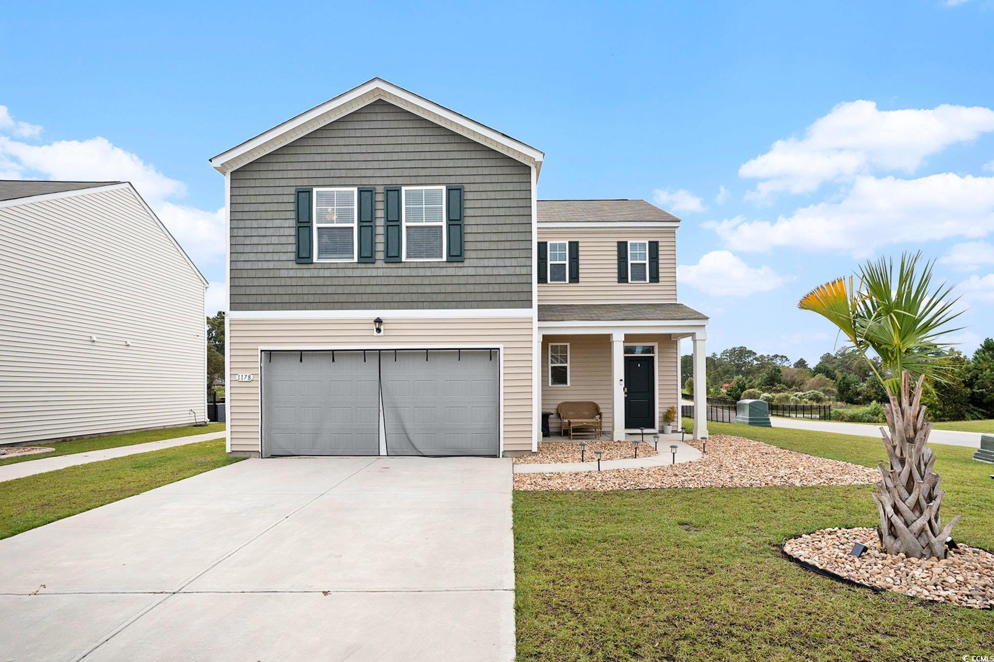 1178 Sennema Circle Myrtle Beach, SC 29588 - Photo 3 of 31 View of front of property featuring a front yard, driveway, a garage, and a porch