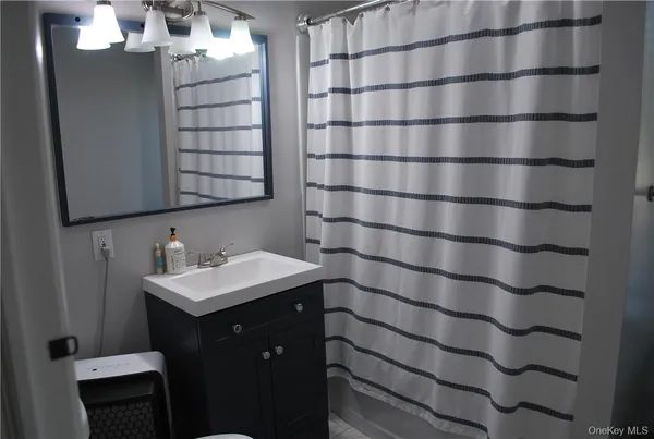 a bathroom with a bath tub sink and mirror