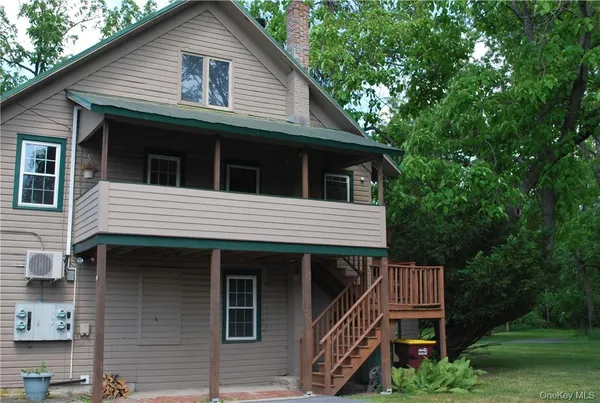 a front view of a house with a wooden deck