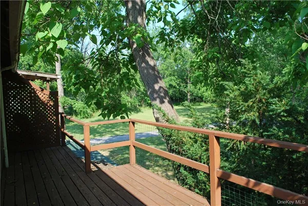 a view of backyard with green space and trees in the background