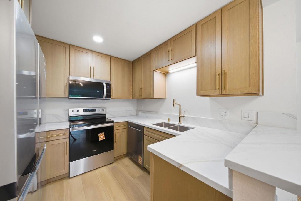 6757 Friars Road, Unit 36 San Diego, CA 92108 - Photo 6 of 23 a kitchen with stainless steel appliances granite countertop a sink stove microwave and refrigerator