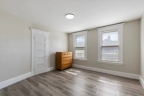 an empty room with wooden floor and closet