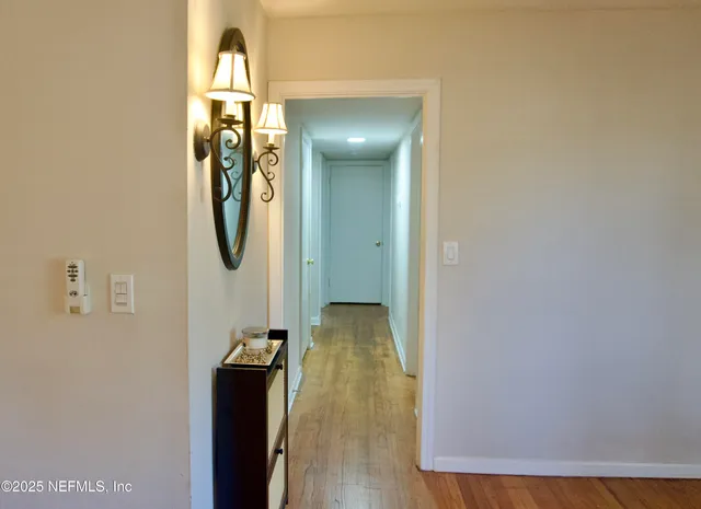 a view of a hallway with wooden floor