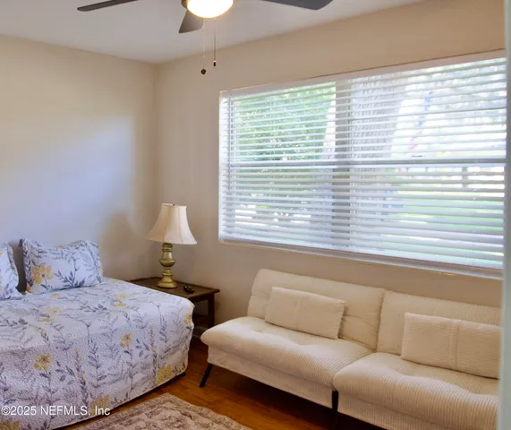 a bedroom with a bed couch and a large window