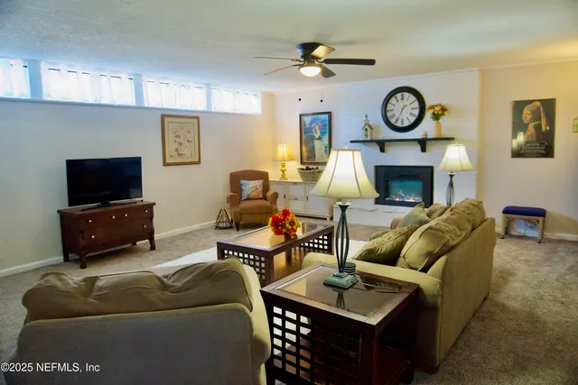 a living room with furniture a clock and a flat screen tv