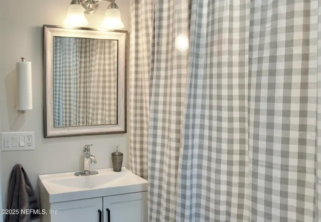 a bathroom with a sink a mirror and shower