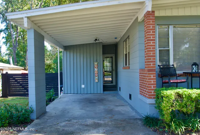 a view of a porch with plants and wooden fence