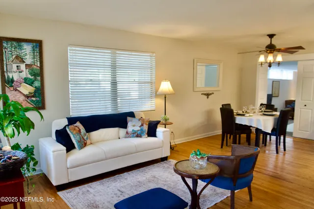a living room with furniture a dining table and a potted plant