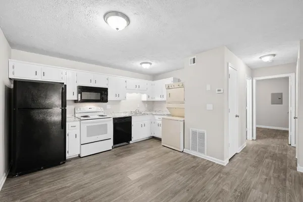 a kitchen with a refrigerator stove and white cabinets