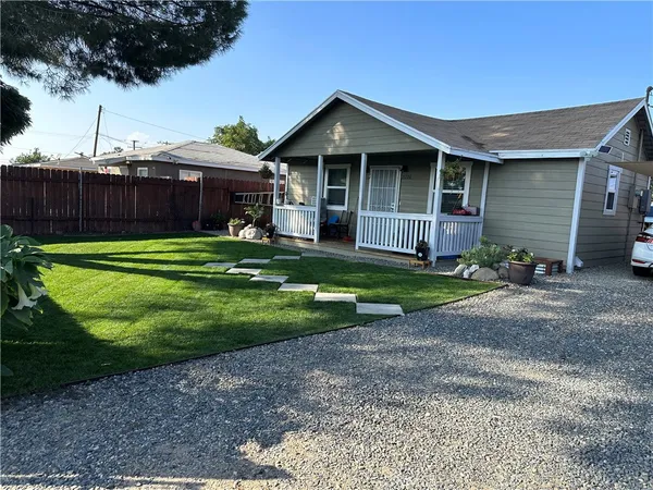 a front view of a house with a yard and trees