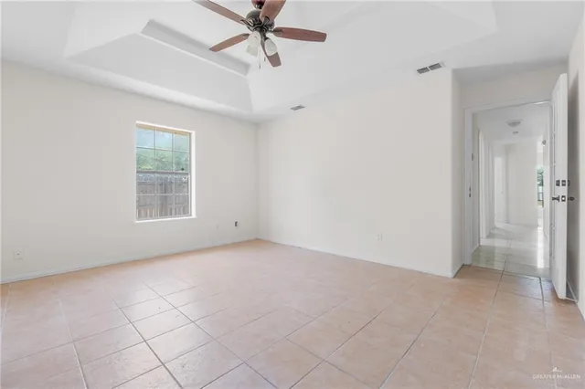 an empty room with a ceiling fan and a window