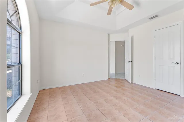 a view of a room with a ceiling fan and a window
