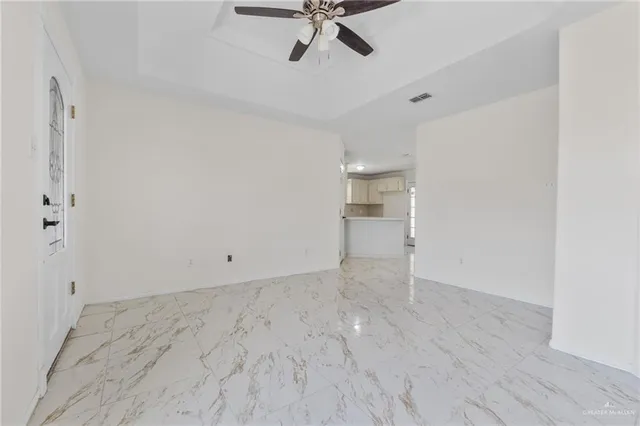 a view of empty room with wooden floor and ceiling fan