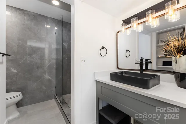 a bathroom with a sink a toilet and a mirror