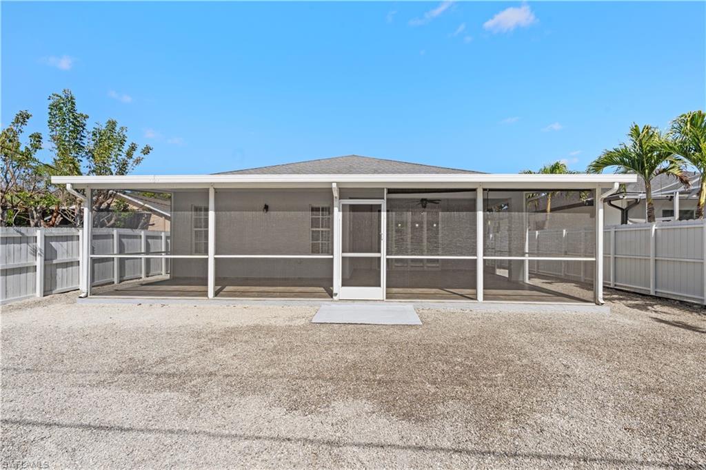183 7th Street Naples, FL 34113 - Photo 38 of 50 Rear view of house with a fenced backyard