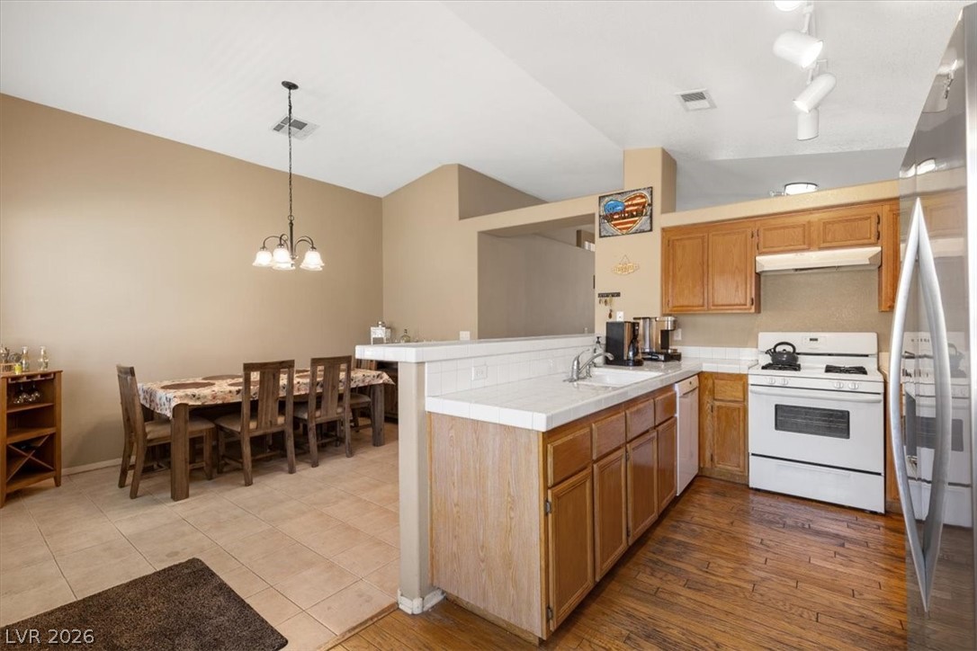 2377 Ramsgate Drive Henderson, NV 89074 - Photo 10 of 25 An open-concept kitchen and dining area features vaulted ceilings and varied flooring.