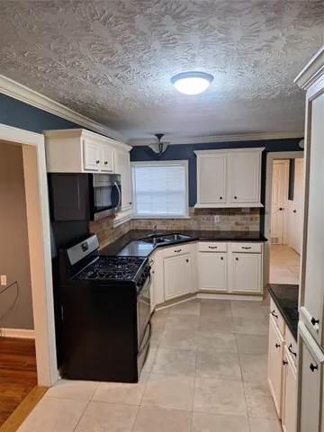 a kitchen with a stove top oven and cabinets