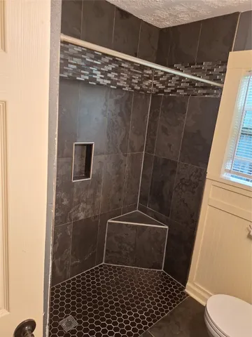 a bathroom with a toilet and a shower