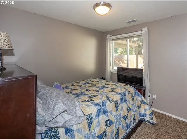 a bedroom with a bed and a window