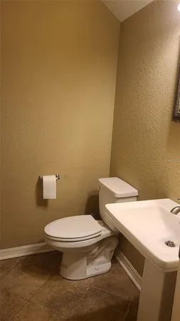 a white toilet sitting next to a white sink and vanity