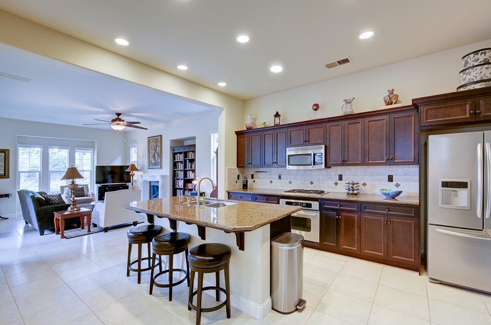 3852 Harlan Ranch Boulevard Clovis, CA 93619 - Photo 12 of 45 a kitchen with stainless steel appliances kitchen island granite countertop a sink and cabinets
