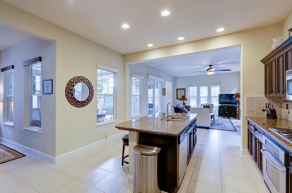 3852 Harlan Ranch Boulevard Clovis, CA 93619 - Photo 15 of 45 a kitchen with stainless steel appliances granite countertop a lot of counter space and wooden floor
