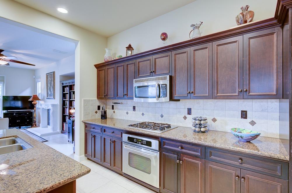 3852 Harlan Ranch Boulevard Clovis, CA 93619 - Photo 16 of 45 a kitchen with stainless steel appliances granite countertop a stove a sink and a microwave