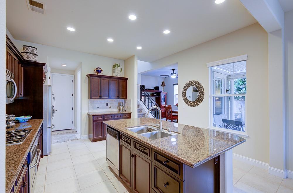 3852 Harlan Ranch Boulevard Clovis, CA 93619 - Photo 17 of 45 a kitchen with a sink dishwasher a stove and a refrigerator with wooden floor