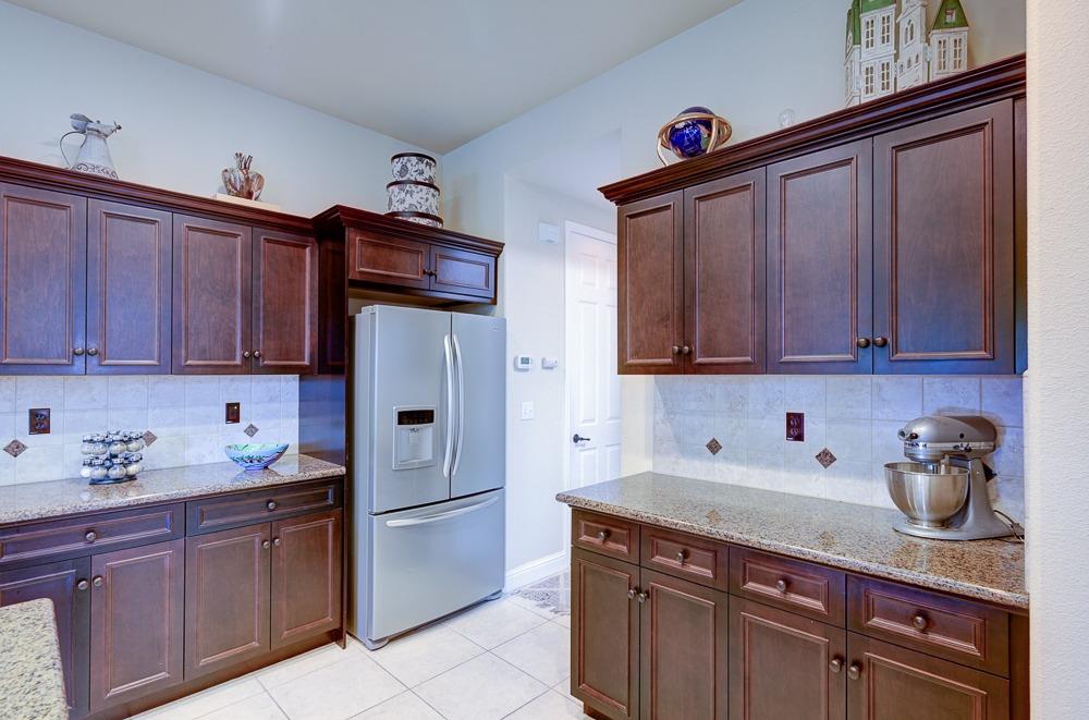 3852 Harlan Ranch Boulevard Clovis, CA 93619 - Photo 18 of 45 a kitchen with stainless steel appliances granite countertop wooden cabinets a sink and dishwasher