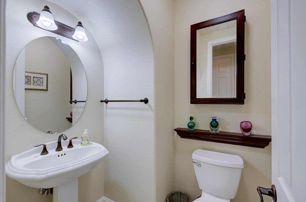 3852 Harlan Ranch Boulevard Clovis, CA 93619 - Photo 19 of 45 a bathroom with a toilet sink and mirror