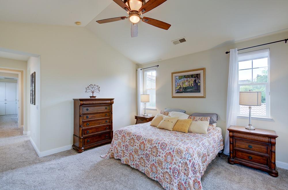 3852 Harlan Ranch Boulevard Clovis, CA 93619 - Photo 21 of 45 a bedroom with a bed and a chandelier