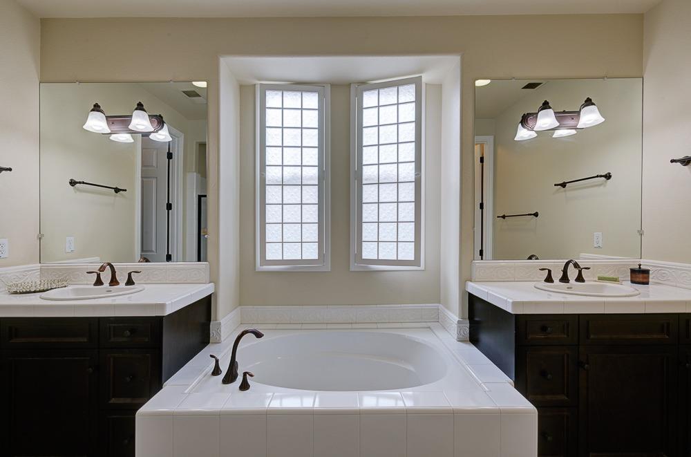 3852 Harlan Ranch Boulevard Clovis, CA 93619 - Photo 23 of 45 a bathroom with a bathtub a sink and mirror