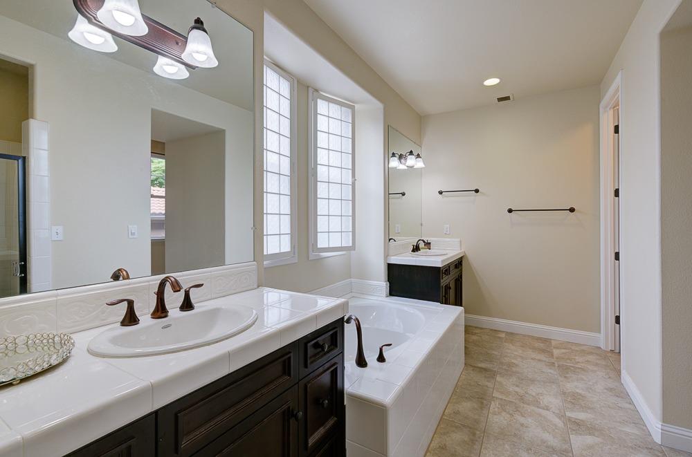 3852 Harlan Ranch Boulevard Clovis, CA 93619 - Photo 24 of 45 a en suite bathroom with a sink and a mirror