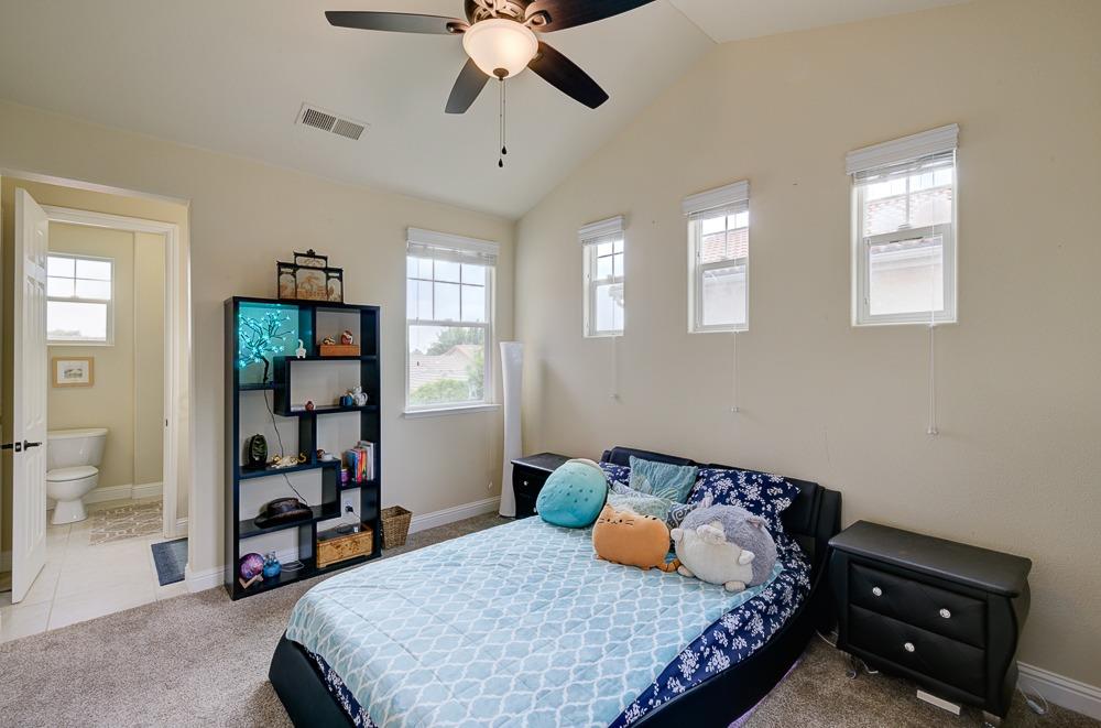 3852 Harlan Ranch Boulevard Clovis, CA 93619 - Photo 31 of 45 a bedroom with a bed and a chandelier