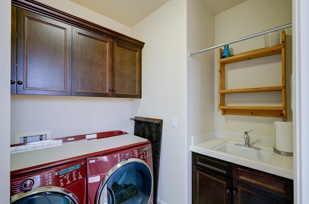 3852 Harlan Ranch Boulevard Clovis, CA 93619 - Photo 32 of 45 a utility room with cabinets and washer