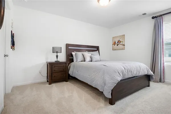 a large bed sitting in a bedroom next to a window
