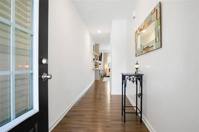 a view of a hallway with wooden floor and staircase