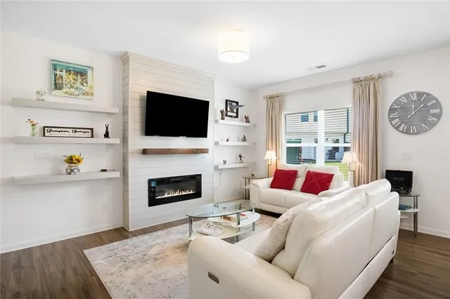 a living room with furniture a flat screen tv and a fireplace