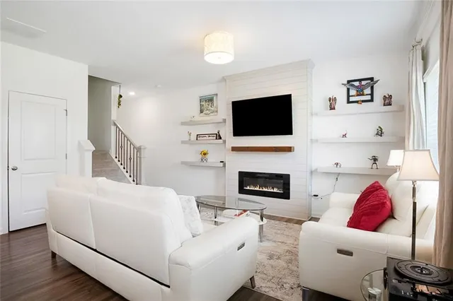 a living room with furniture a fireplace and a flat screen tv