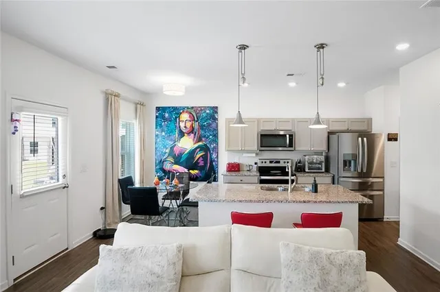 a kitchen with stainless steel appliances kitchen island granite countertop a stove and a sink