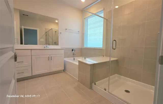 a bathroom with a tub sink and mirror