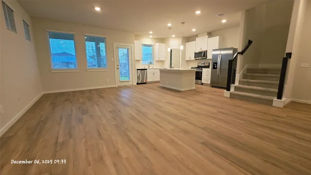 a view of a kitchen with wooden floor and windows