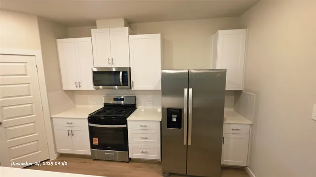a kitchen with stainless steel appliances a refrigerator stove and microwave