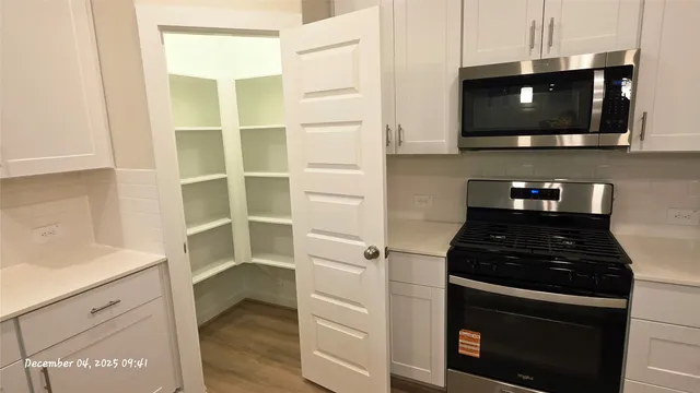 a kitchen with stainless steel appliances a stove and a microwave